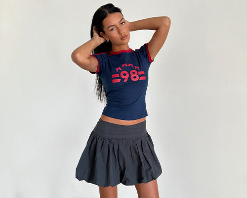 image of Salda Tee in Navy with Adrenaline Red Binding and '98' Emb and Kiyowo Puffball Mini Skirt In Charcoal Grey