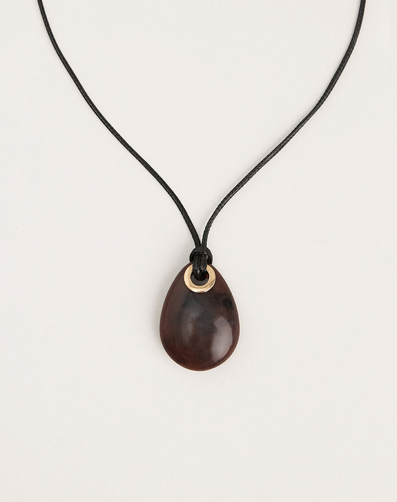 Photo d'un collier à cordon noir avec un pendentif ovale