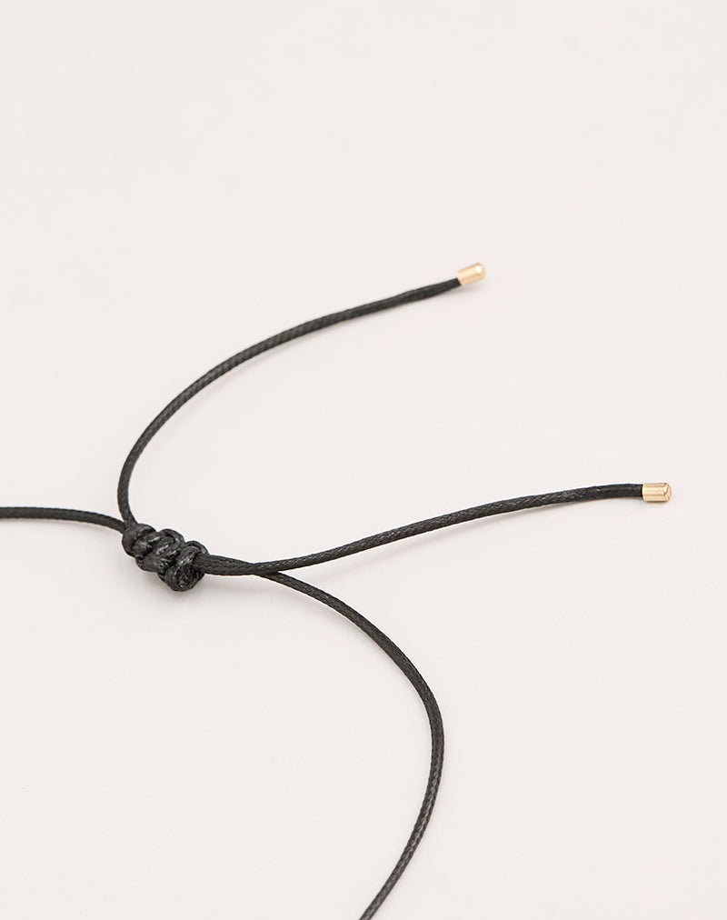 Photo d'un collier à cordon noir avec un pendentif ovale
