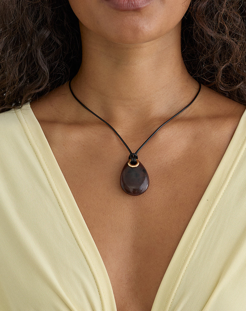 Photo d'un collier à cordon noir avec un pendentif ovale